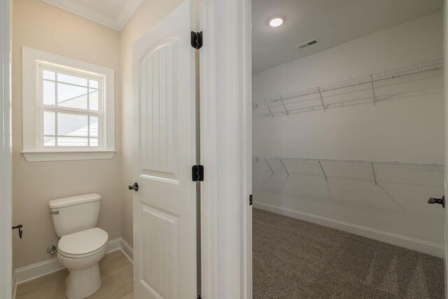 9089 Knolling Loop Unit 87, Ooltewah, TN 37363 - bathroom featuring a walk in closet, toilet, baseboards, and ornamental molding