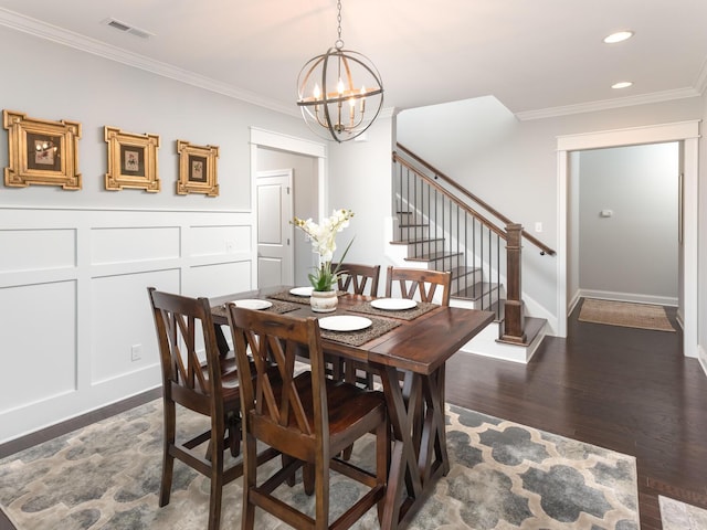 dining space featuring dark hardwood / wood-style flooring, crown molding, and a chandelier