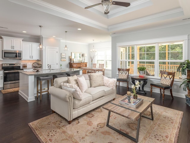 living room featuring dark hardwood / wood-style flooring, crown molding, and a wealth of natural light