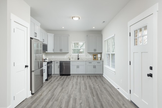 kitchen featuring stainless steel appliances, light hardwood / wood-style flooring, and sink