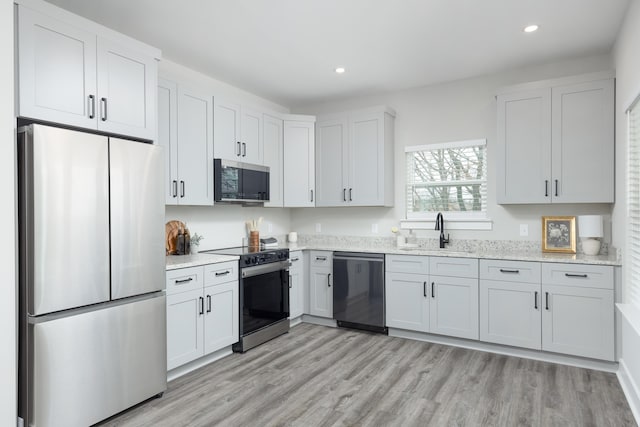 kitchen featuring light stone countertops, sink, white cabinets, and appliances with stainless steel finishes