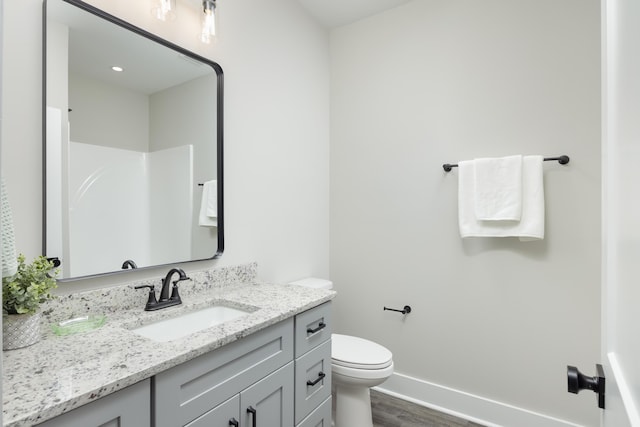 bathroom featuring a shower, hardwood / wood-style floors, vanity, and toilet