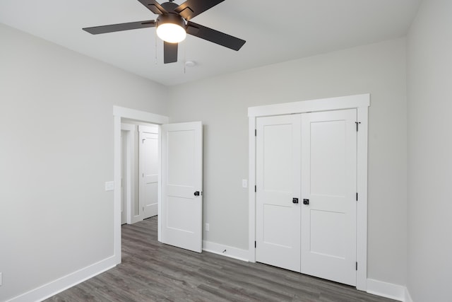 unfurnished bedroom featuring ceiling fan, dark hardwood / wood-style flooring, and a closet