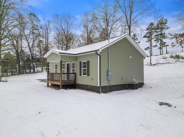 snow covered property with cooling unit