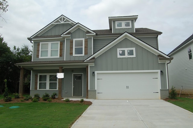 craftsman house with a front lawn and a garage