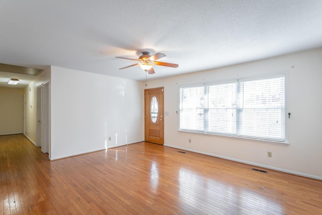 unfurnished living room featuring light wood-type flooring, ceiling fan, and a healthy amount of sunlight