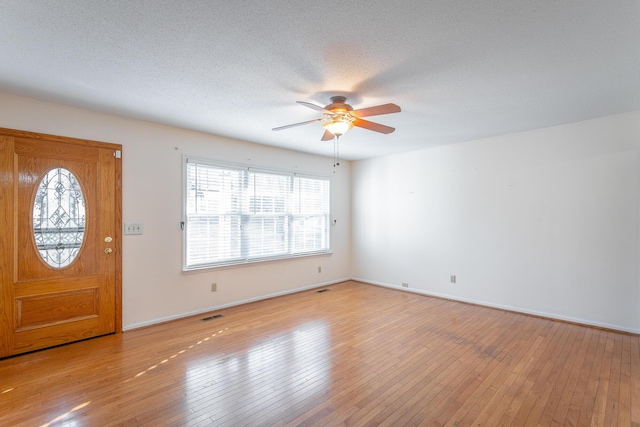 entrance foyer featuring ceiling fan, a healthy amount of sunlight, light wood-type flooring, and a textured ceiling