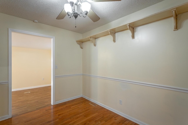 empty room featuring hardwood / wood-style flooring, ceiling fan, and a textured ceiling