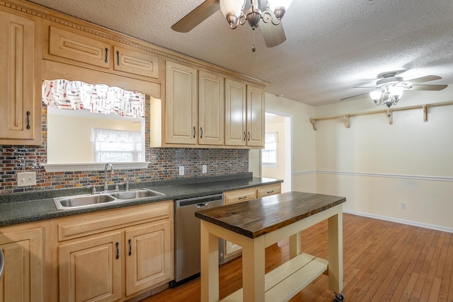 kitchen with light wood-type flooring, tasteful backsplash, a textured ceiling, sink, and dishwasher