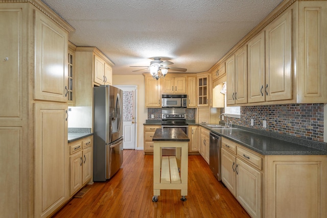 kitchen featuring backsplash, a center island, stainless steel appliances, and wood-type flooring