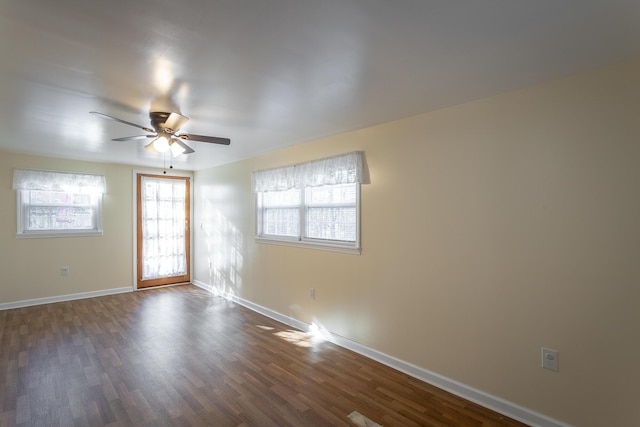 empty room with dark hardwood / wood-style flooring and ceiling fan