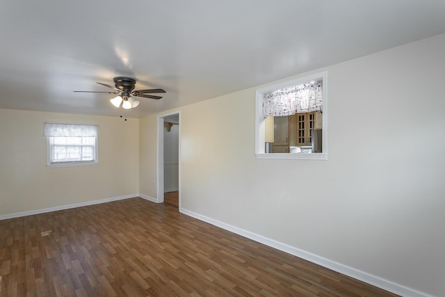 empty room with ceiling fan and dark hardwood / wood-style flooring