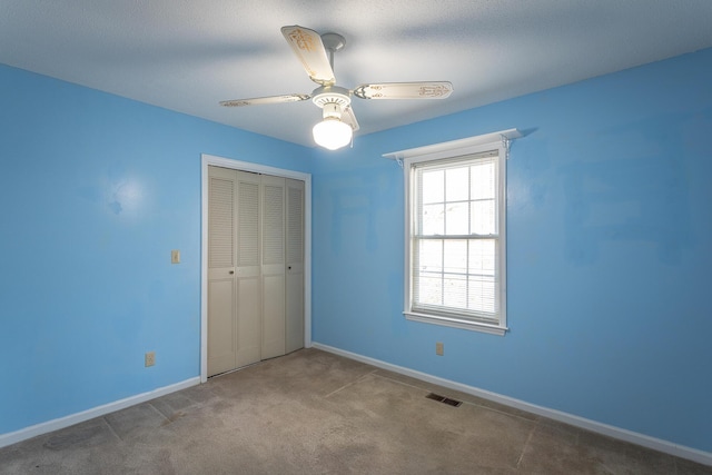 unfurnished bedroom featuring ceiling fan, light carpet, and a closet