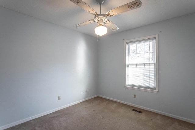 spare room featuring carpet and ceiling fan