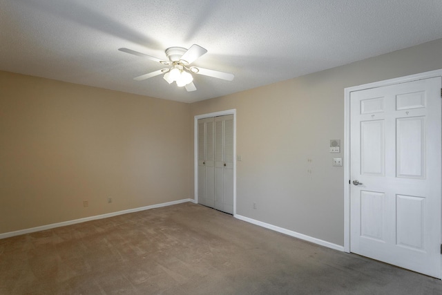 empty room featuring carpet, ceiling fan, and a textured ceiling