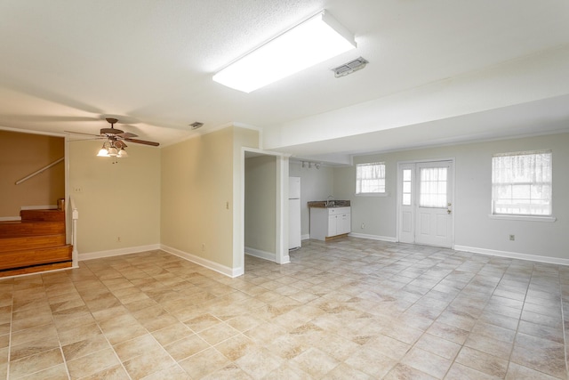 basement featuring ceiling fan and white fridge