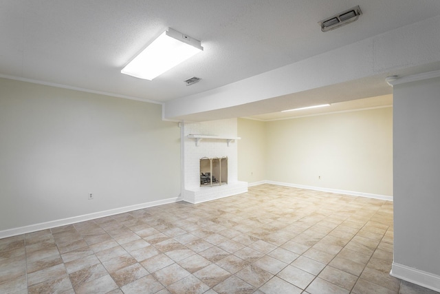 basement with a fireplace, a textured ceiling, and ornamental molding