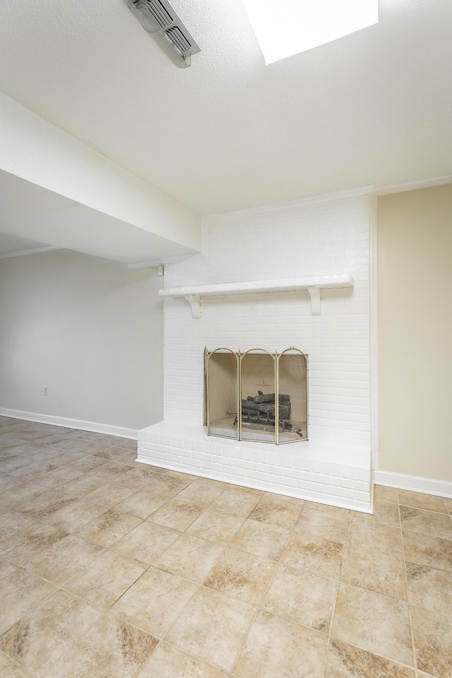 basement featuring a textured ceiling and a brick fireplace