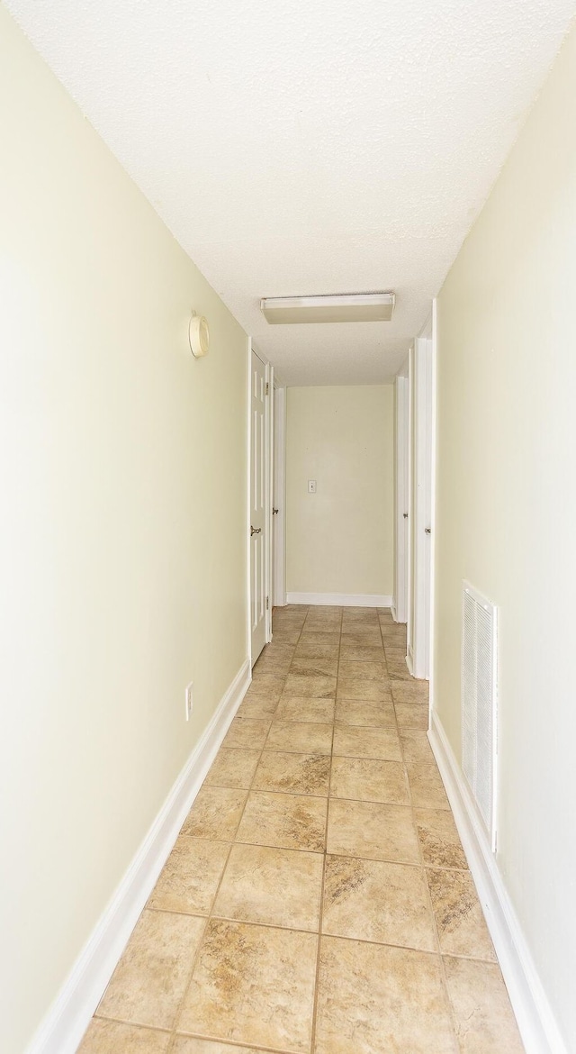 hall featuring a textured ceiling