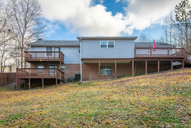 back of house featuring cooling unit, a deck, and a yard