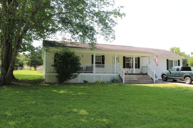 ranch-style house featuring covered porch and a front yard