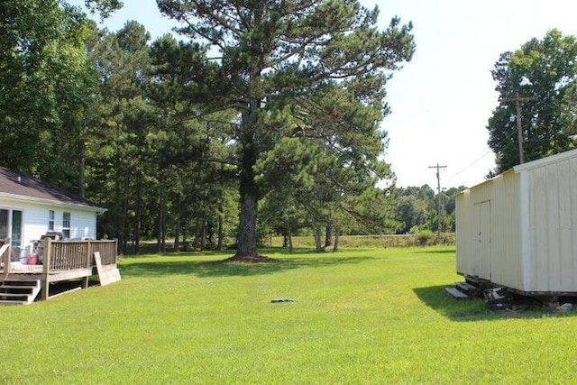 view of yard featuring a deck and a storage unit