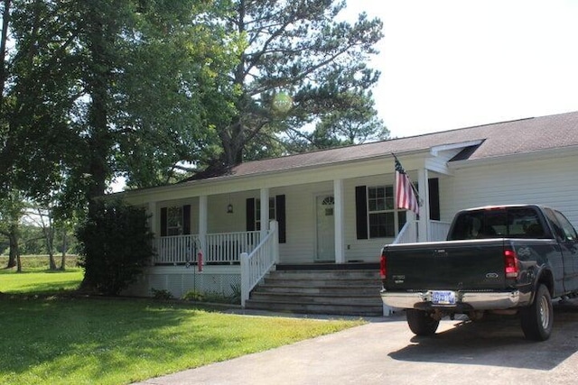 ranch-style home with a porch and a front yard