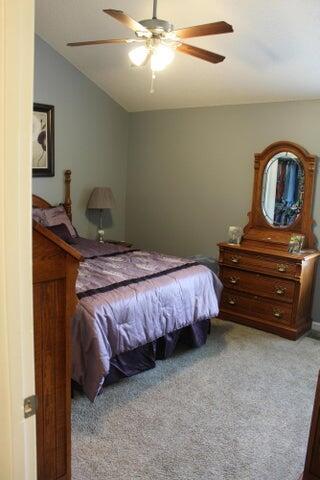 bedroom with ceiling fan, light carpet, and lofted ceiling