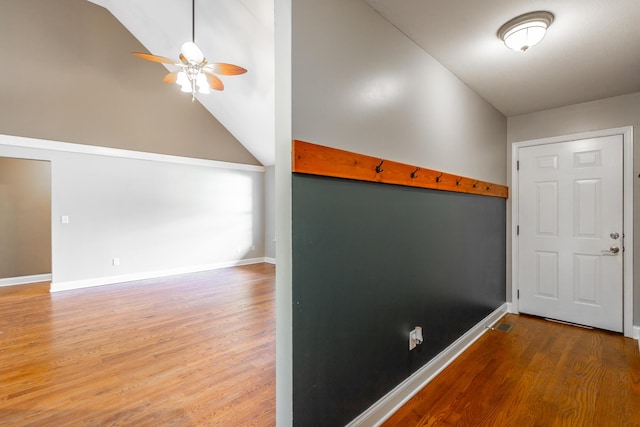 interior space featuring high vaulted ceiling, ceiling fan, baseboards, and wood finished floors