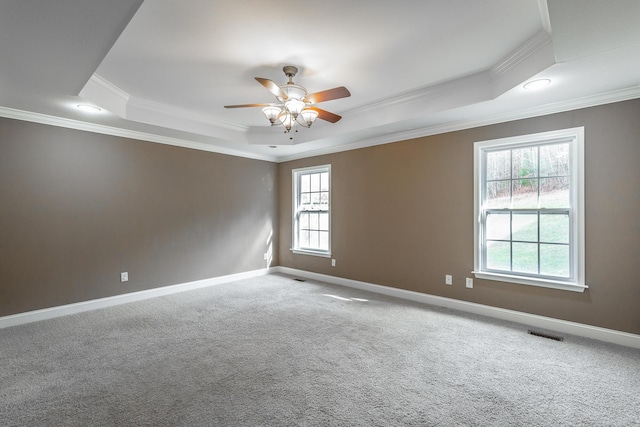 unfurnished room with a tray ceiling, visible vents, and baseboards