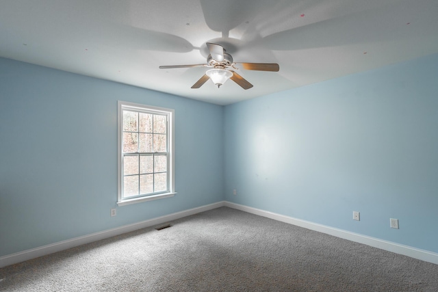 spare room featuring ceiling fan, carpet, visible vents, and baseboards