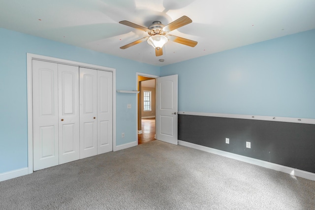 unfurnished bedroom with ceiling fan, a closet, carpet, and baseboards