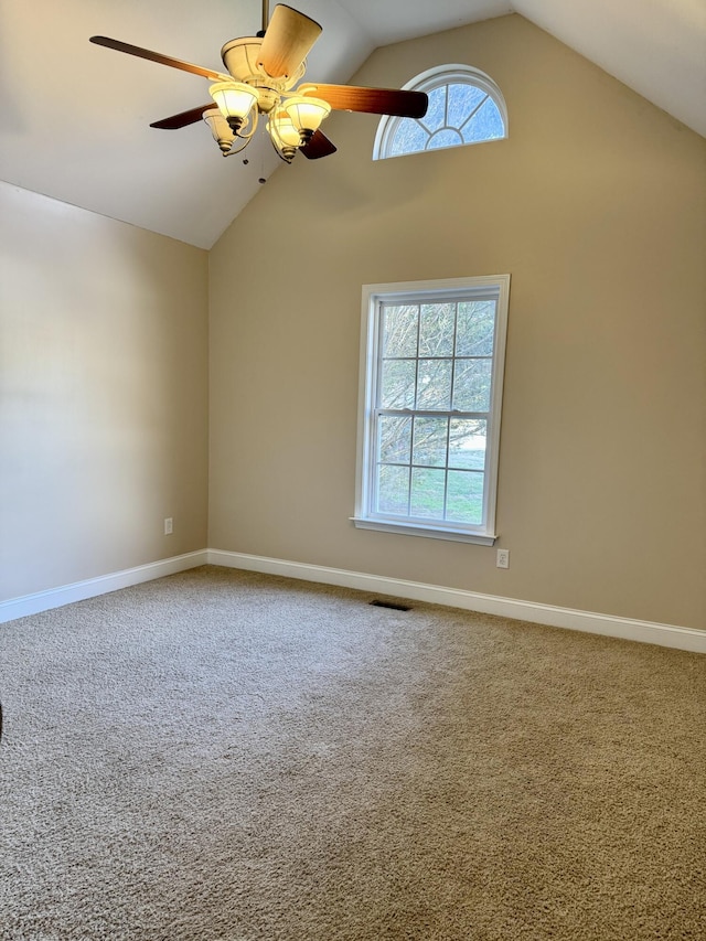 carpeted empty room with high vaulted ceiling, ceiling fan, visible vents, and baseboards