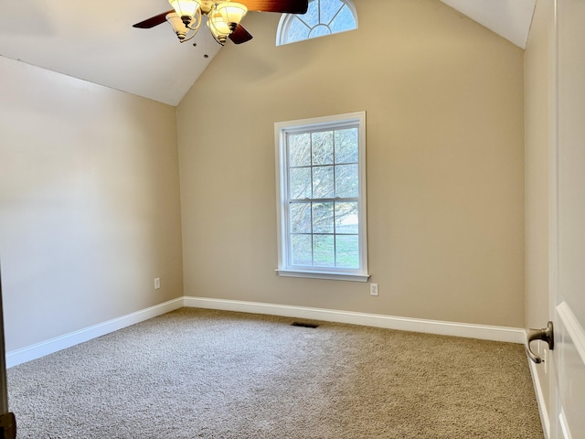 carpeted empty room featuring lofted ceiling, visible vents, baseboards, and a ceiling fan