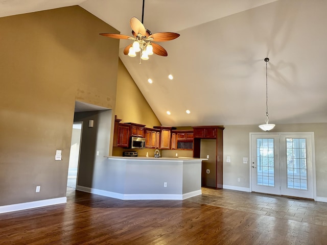 kitchen with baseboards, ceiling fan, stainless steel microwave, dark wood-style flooring, and light countertops