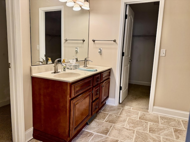 full bathroom with double vanity, baseboards, and a sink