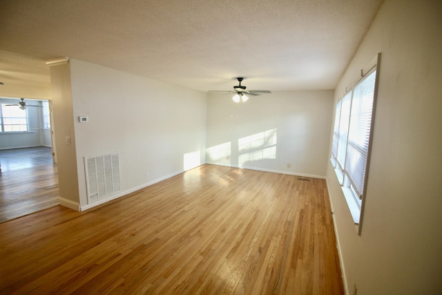 unfurnished room with ceiling fan, a textured ceiling, and hardwood / wood-style flooring