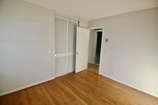 unfurnished bedroom with light hardwood / wood-style flooring and a closet