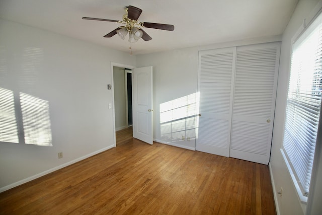 unfurnished bedroom featuring a closet, hardwood / wood-style flooring, and ceiling fan