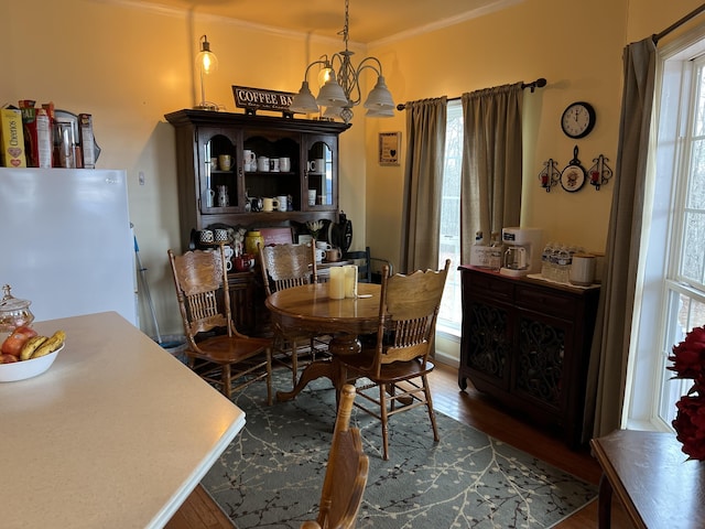 dining area with dark hardwood / wood-style flooring, a wealth of natural light, and crown molding