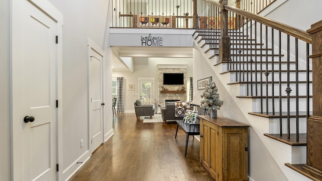 interior space with a fireplace, a high ceiling, and dark hardwood / wood-style flooring