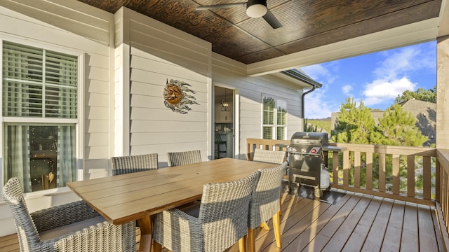 wooden deck with ceiling fan and area for grilling