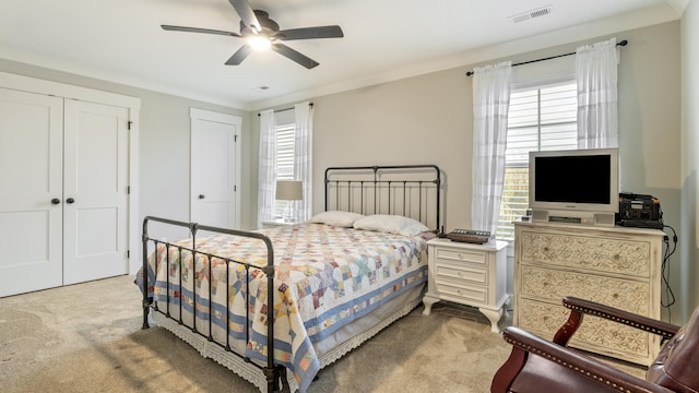 carpeted bedroom featuring ceiling fan and crown molding