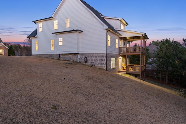 property exterior at dusk featuring a balcony