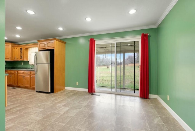 kitchen with stainless steel fridge, light tile patterned floors, and ornamental molding