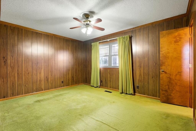 unfurnished room featuring wood walls and light colored carpet