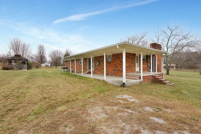 view of property exterior featuring a porch, a yard, and a gazebo