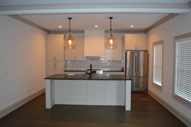 kitchen featuring white cabinets, custom range hood, high end fridge, and an island with sink