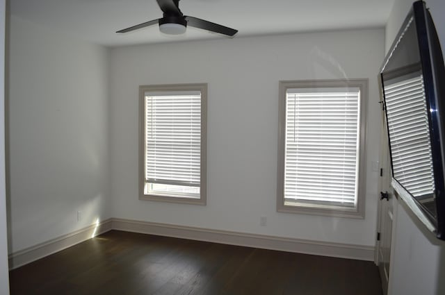 unfurnished room with dark hardwood / wood-style flooring, plenty of natural light, and ceiling fan