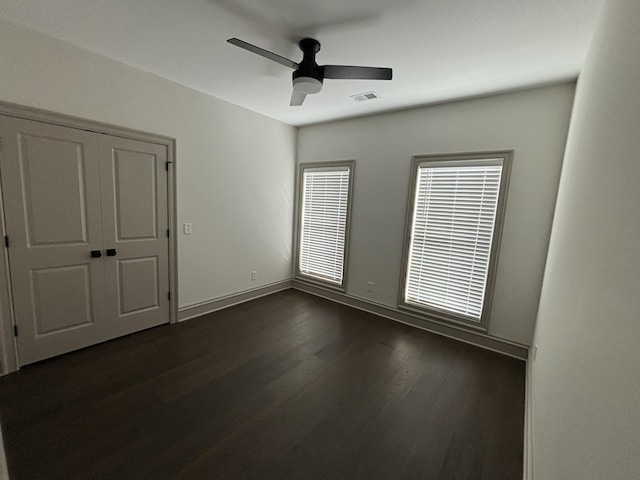 spare room with dark hardwood / wood-style floors and ceiling fan